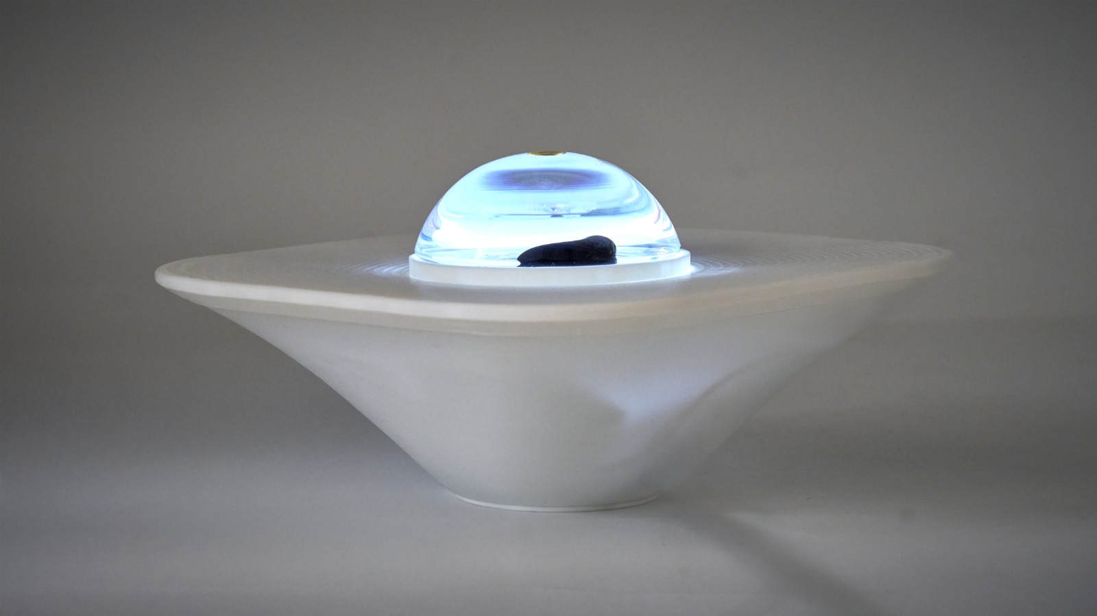Feral Focus device close-up showing the ferrofluid dome and 3D-printed enclosure