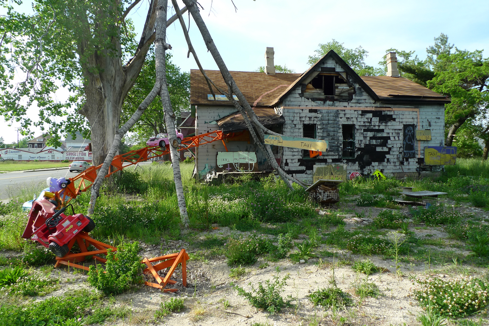 The lot with orange steel structure and abandoned house